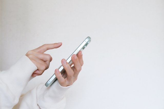 スマートフォンを操作する手の写真