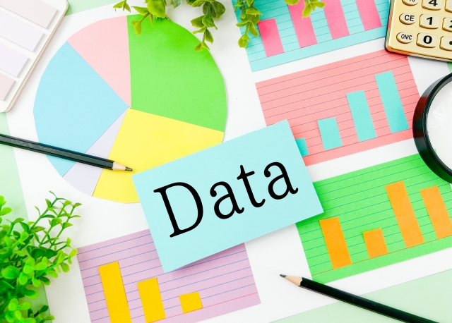 デスクの上のグラフや「Data」と書かれた付箋のイラスト