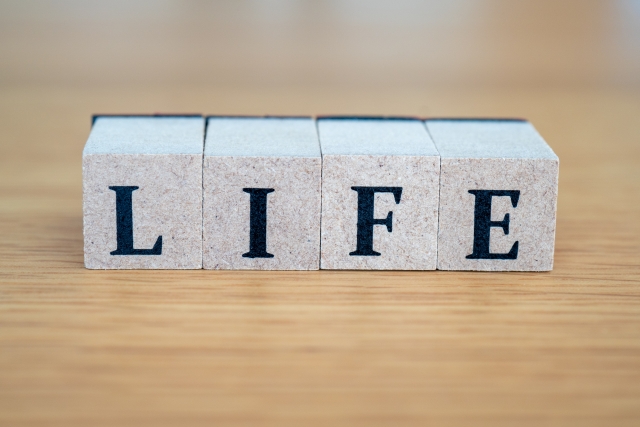 テーブルの上にブロックで「LIFE」と書かれたイラスト