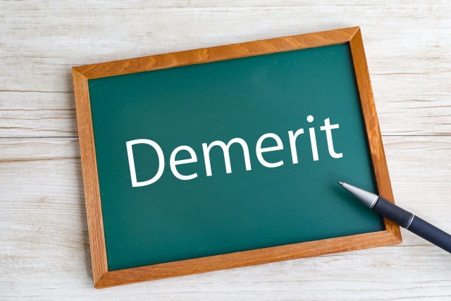 小さなボードに「Demerit」と書かれたイラスト