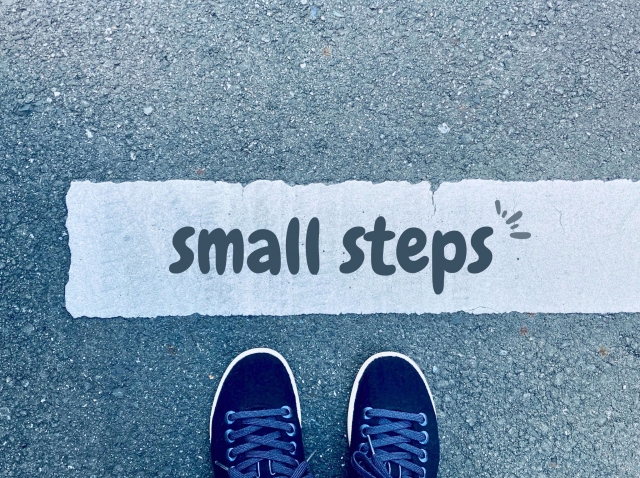 道路に書かれた「small steps」の文字と靴のイラスト