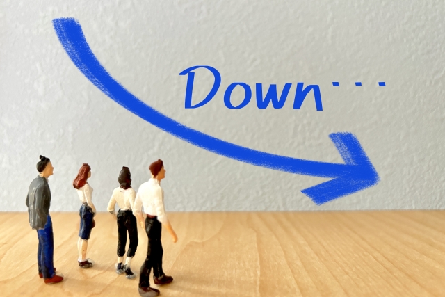 4人のビジネスマンが「Down」の文字と右肩下がりの矢印を眺めるイラスト