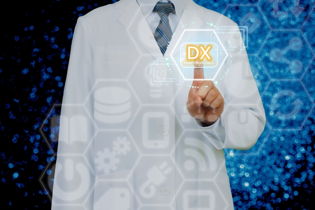 男性医師が「DX」と書かれたボタンを押している画像