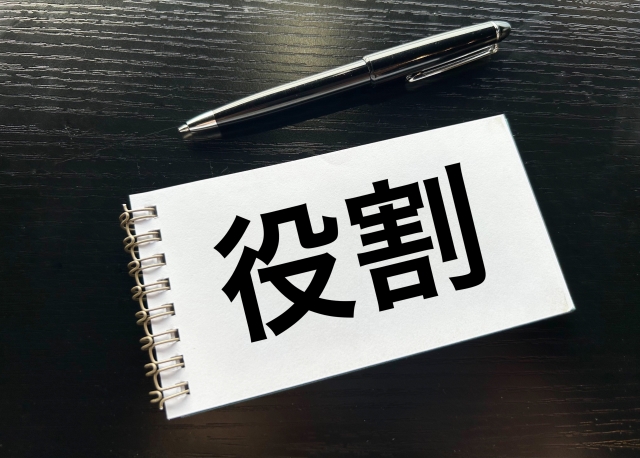 デスクの上のメモ帳に「役割」と書かれたイラスト