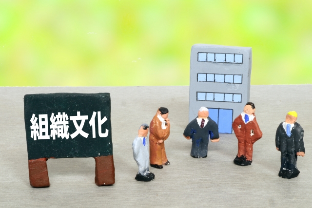 「組織文化」と書かれた看板とサラリーマンの模型のイラスト