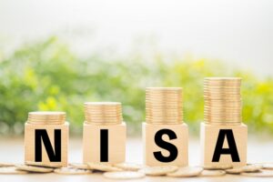「NISA」と書かれたブロックに硬貨が積み重ねられたイラスト