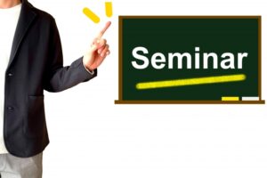 黒板に書かれた「Seminar」の文字を指す男性のイラスト
