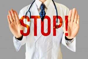 男性医師が両手で「STOP！」のポーズをしている画像
