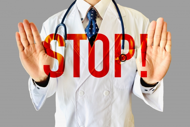 男性医師が両手で「STOP！」のポーズをしている画像