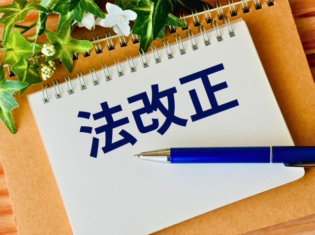 デスク上のノートに「法改正」と書かれたイラスト
