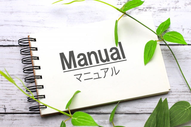 メモ帳に「Manual(マニュアル)」と書かれたイラスト