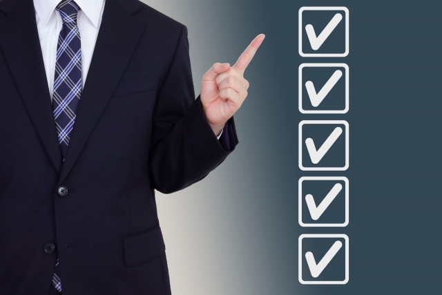 男性ビジネスマンがチェックマークを指しているイラスト