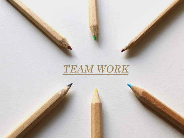 「TEAM WORK」の文字と6本の色鉛筆のイラスト