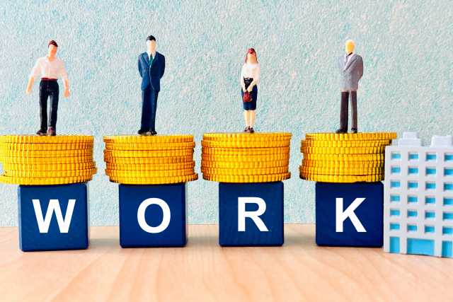 「WORK」と書かれたブロックの上に立つ4体のミニチュア