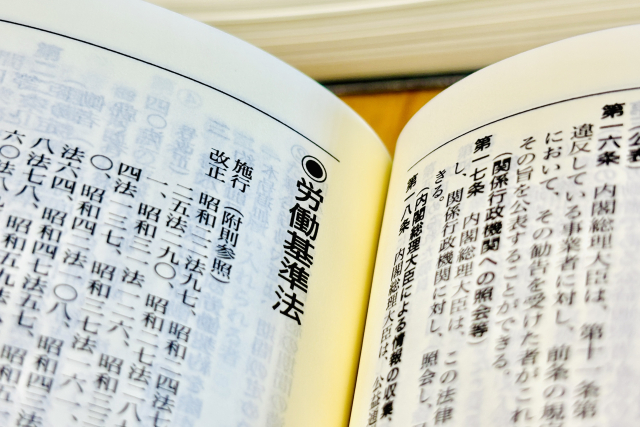 「労働基準法」の文字を焦点にした法律書の画像