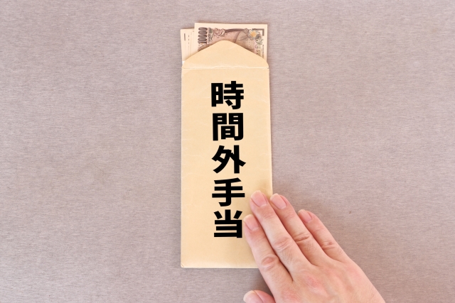 お札の入った封筒に「時間外手当」と書かれたイラスト
