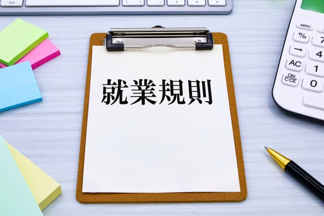 クリップボードの紙に「就業規則」と書かれたイラスト